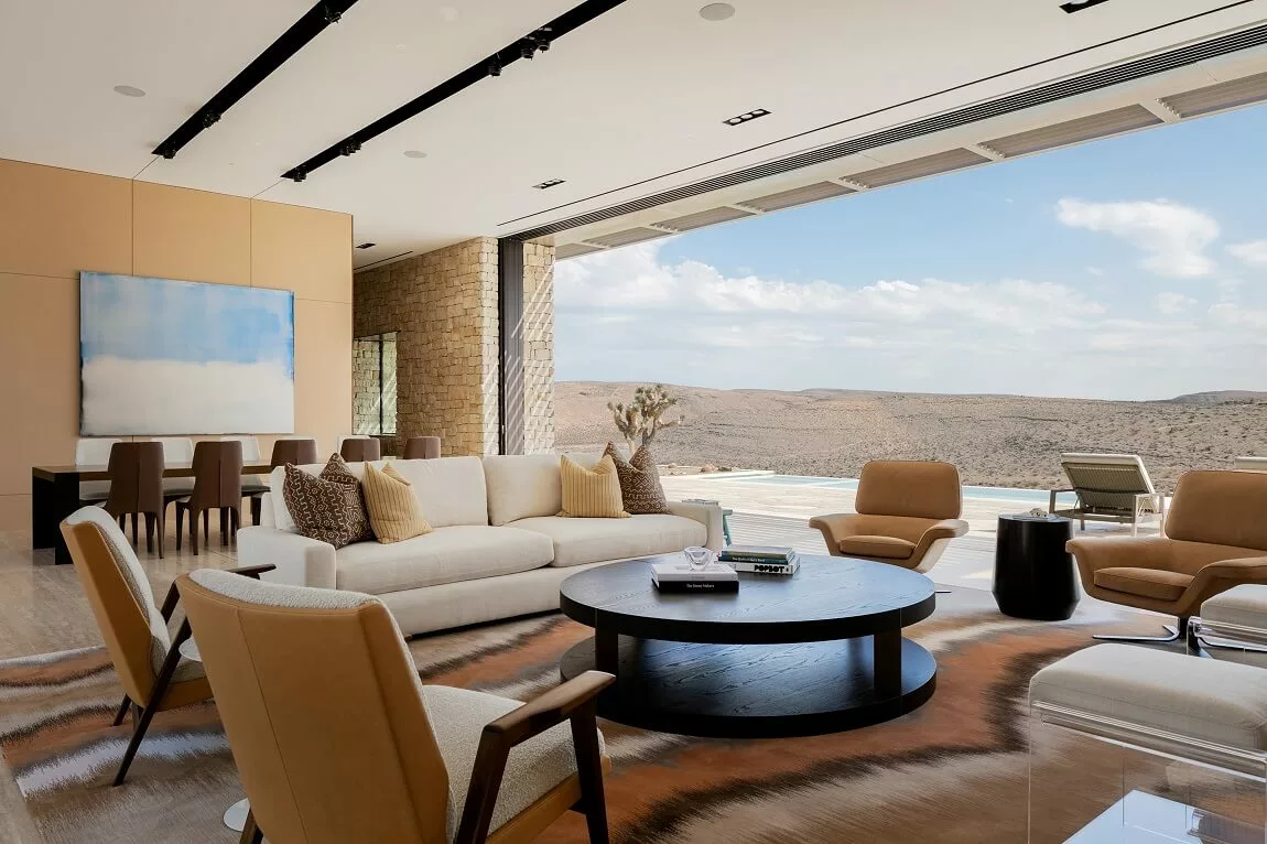 Neutral luxury living room opening to a desert landscape