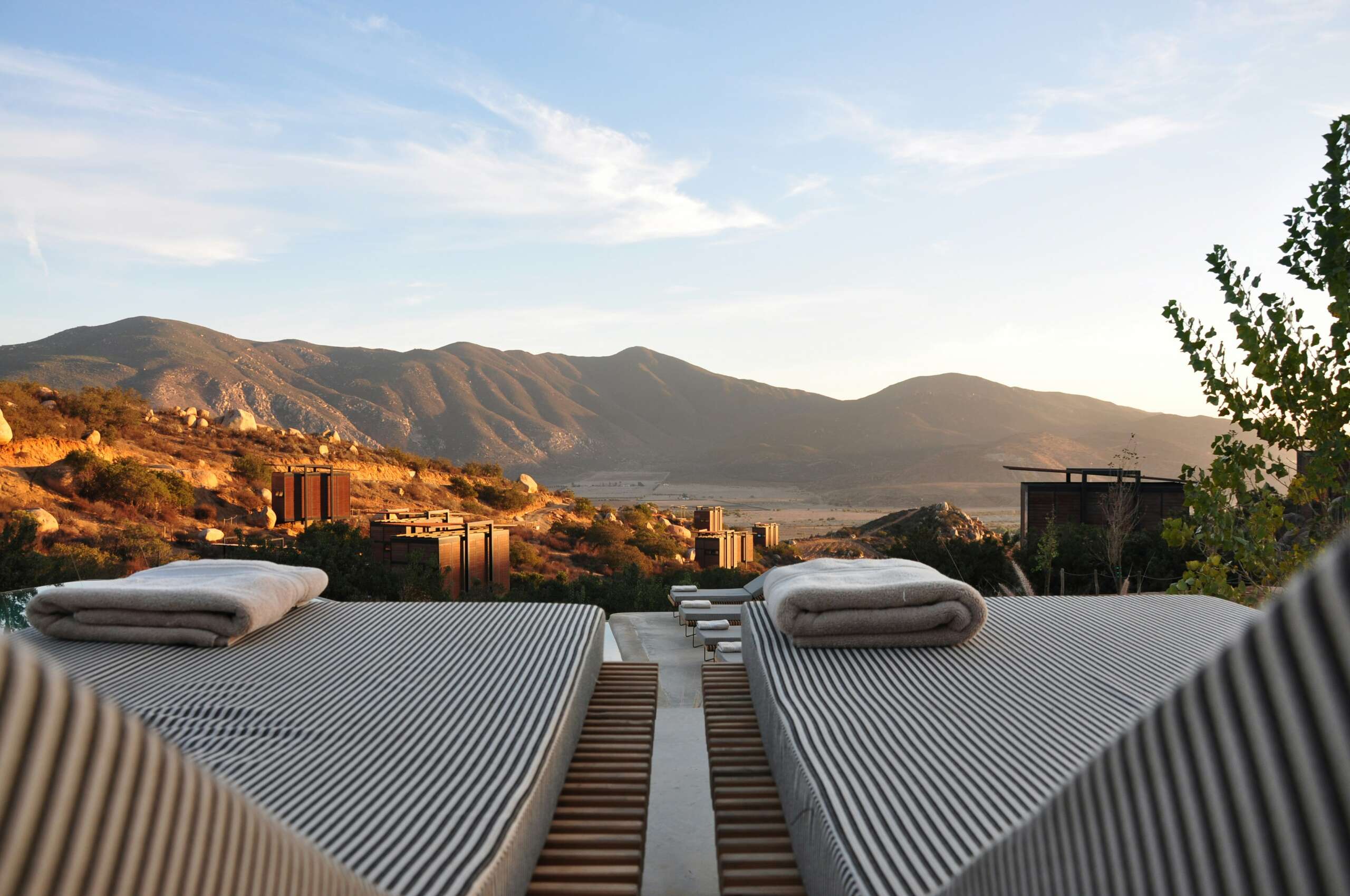 Terrace loungers overlooking a mountain valley at golden hour